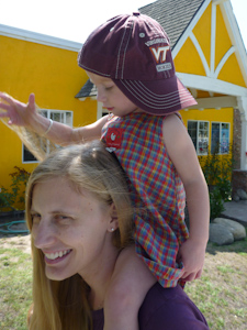 Adria on Amanda's shoulders in Dad's cap
