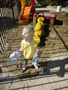 Adria "helping" with the sand in Dad's gloves Adria "helping" with the sand in Dad's gloves