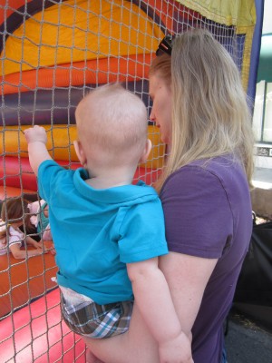 Amanda and Austin watching Adria in the bounce house